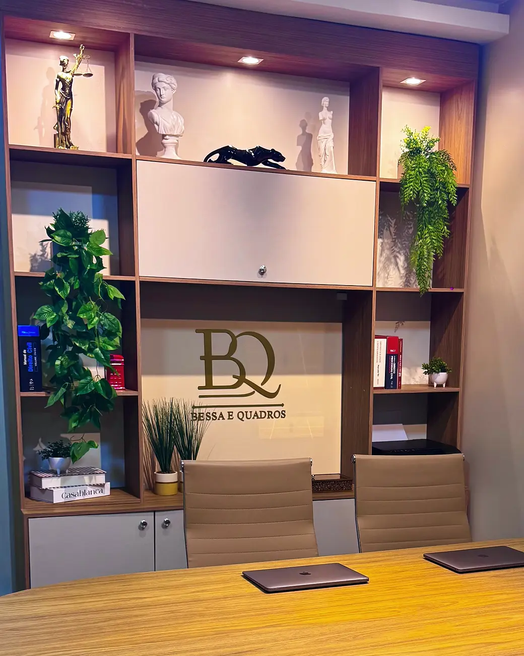 Sala de reunião do escritório Bessa & Quadros em Castanhal, com a marca na parede ao fundo